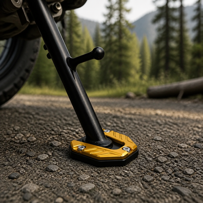 Gold CNC kickstand pad on a motorcycle side stand over gravel