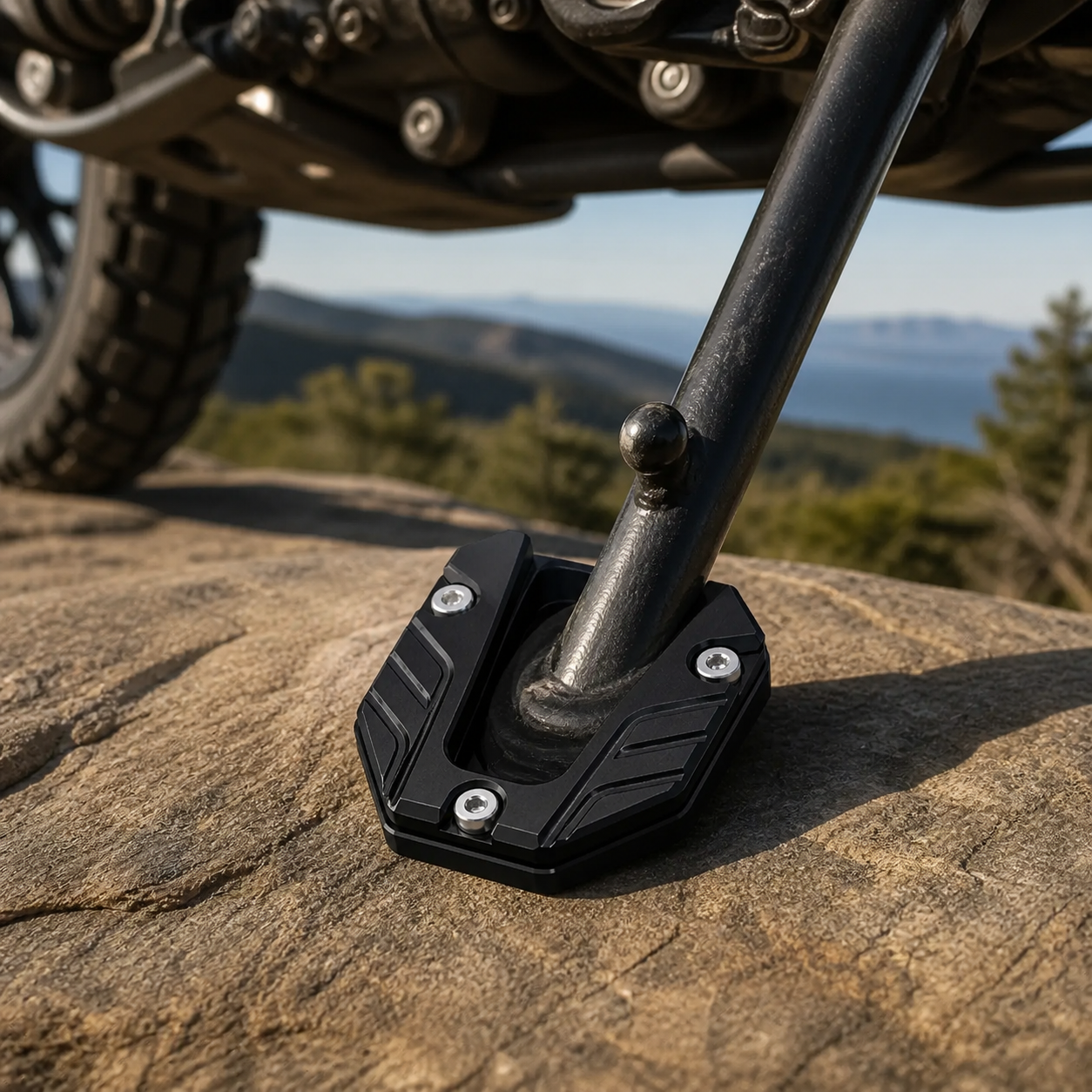 Black CNC kickstand pad at a rocky roadside motorcycle rest stop