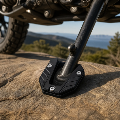 Black CNC kickstand pad at a rocky roadside motorcycle rest stop